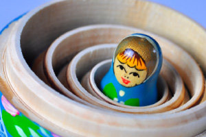 Picture of small wooden doll, at the heart of a set of russian matroshyka dolls