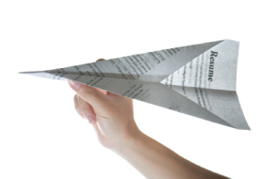Picture of someone making a resume into a targeted paper airplane